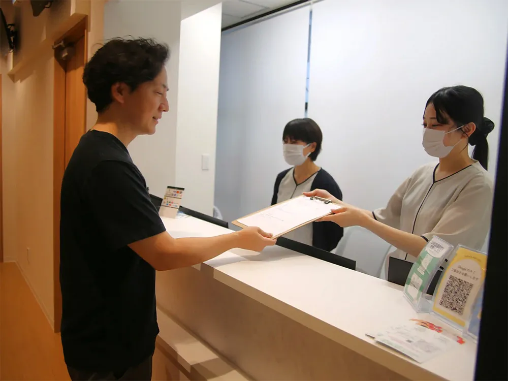 インフィニティヘアクリニック静岡院で受付を済ませる統括院長